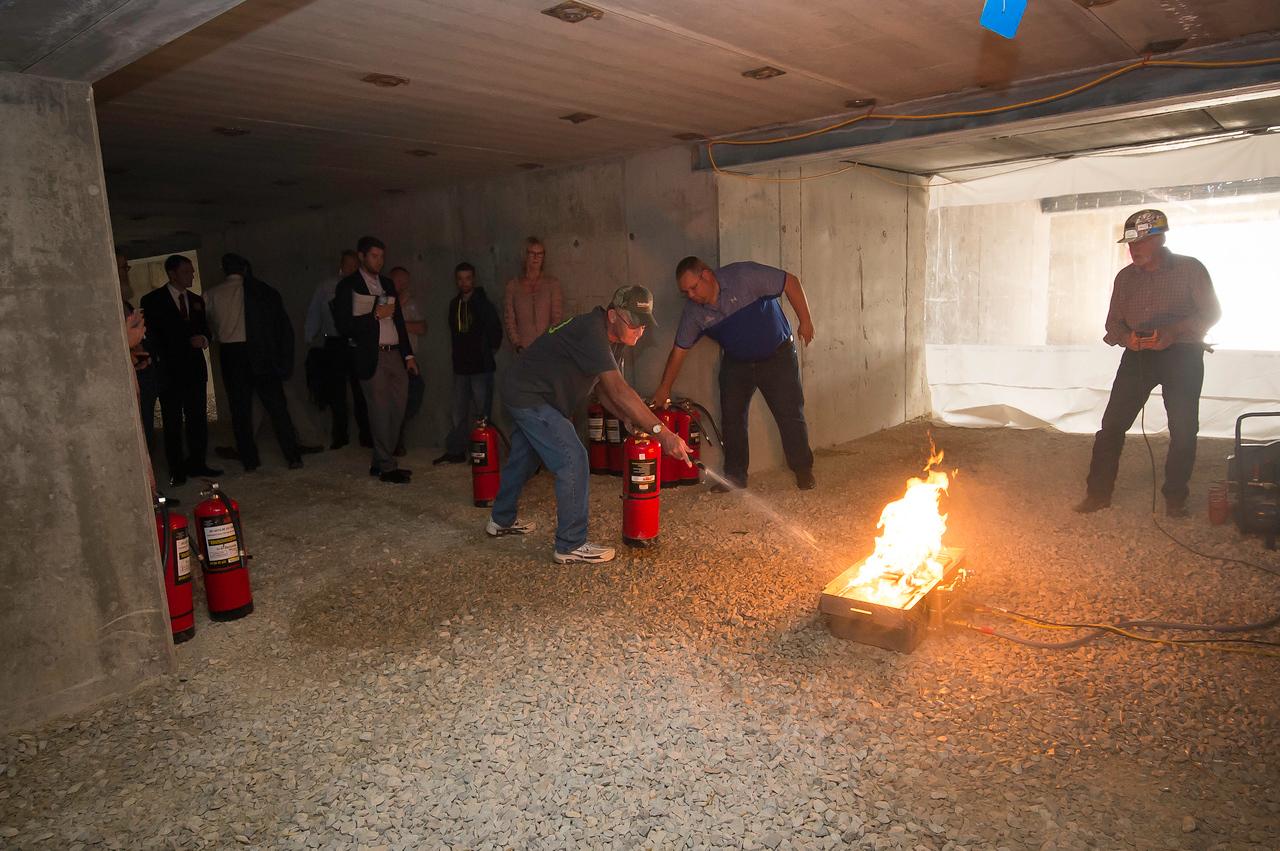 A photo of a man using a fire extinguisher