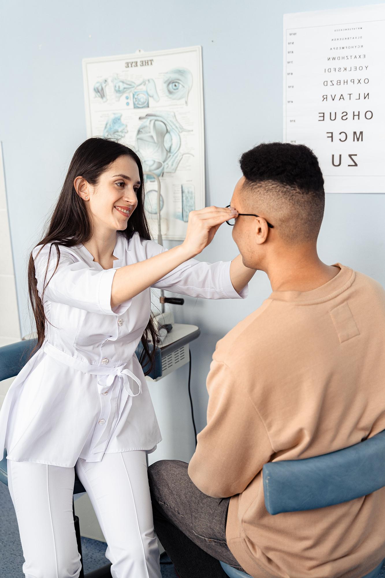 An optometrist giving her patient a pair of glasses