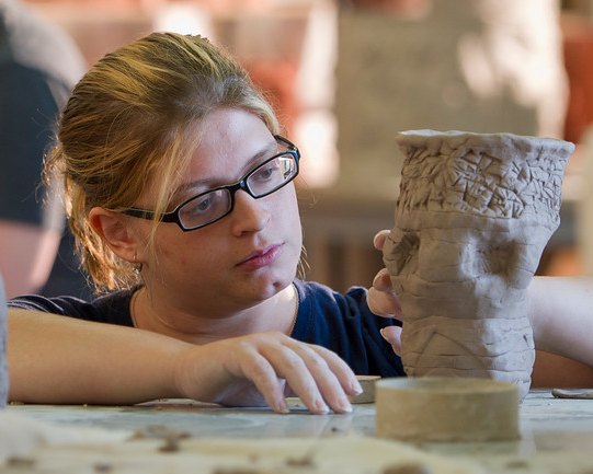 一个女学生在用粘土做雕塑